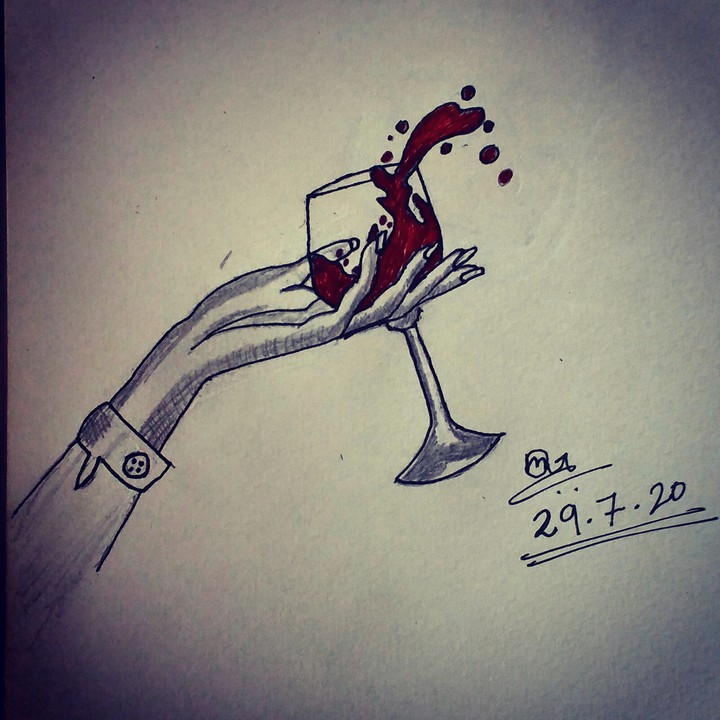 A hand holding a glass of red wine..