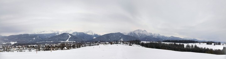 Panoramic photo of polish mountains covered in snow.