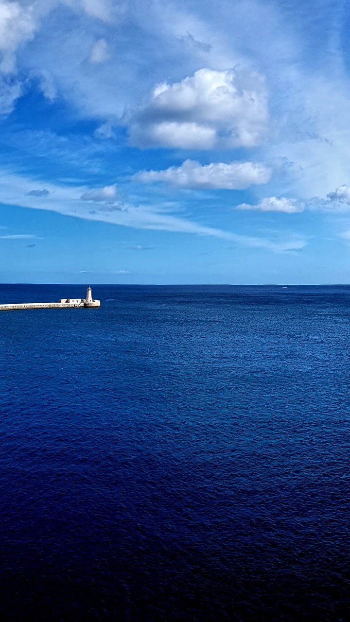 Tiny lighthouse surrounded by the blue Mediterranean Sea