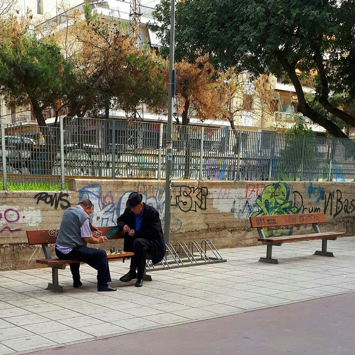 Elderly men while they are playing chess.