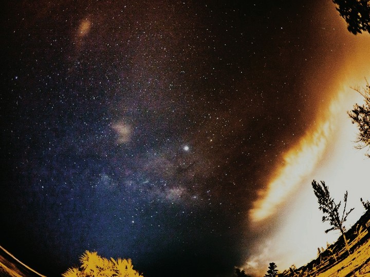 Milky way shadowed by city lights