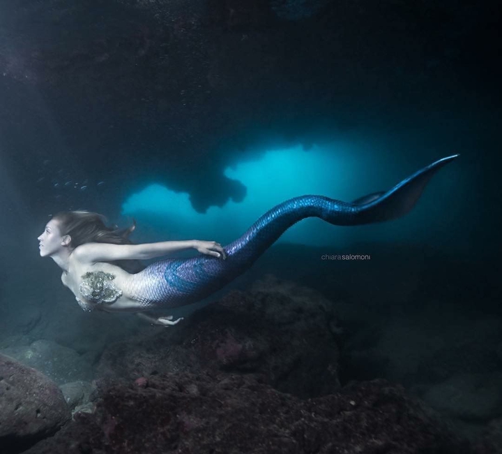 MERMAID SWIMMING IN THE BLUE ABYSS