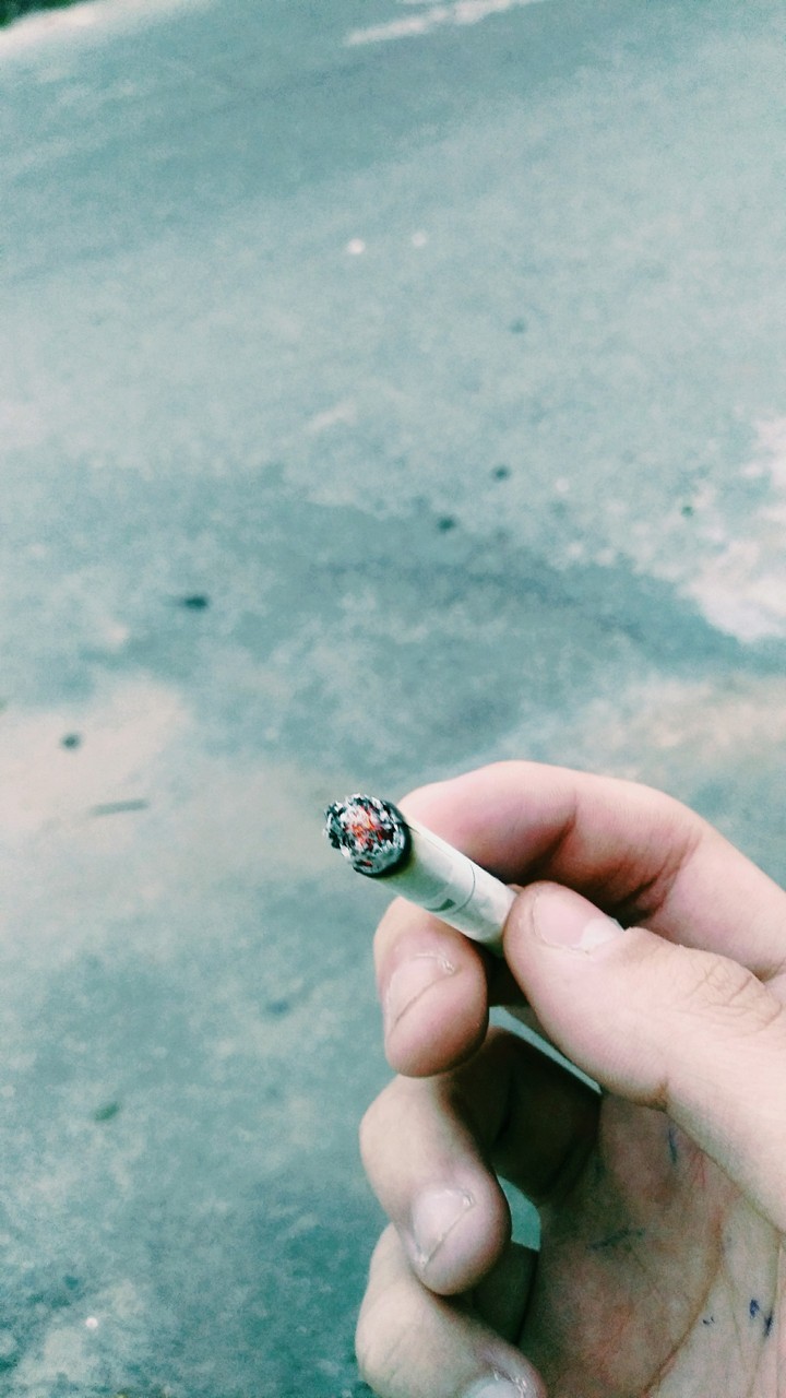 Holding a lit Cigarrete