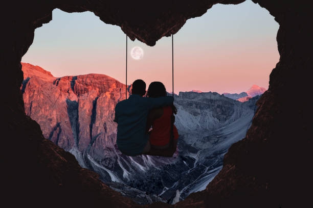 Couple on swing contemplating the mountains in a romantic -
