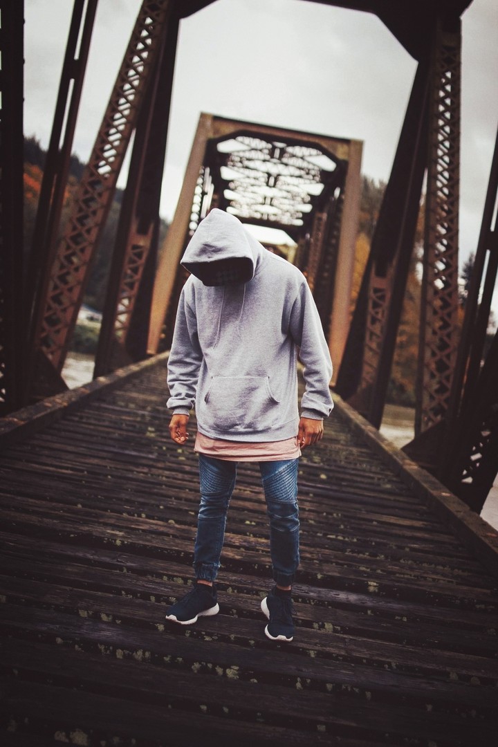 hooded figure on bridge