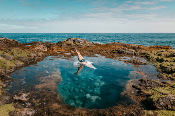 Low Section Of Man Diving In Sea Surrounded