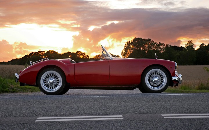 Red coupe soft top on road