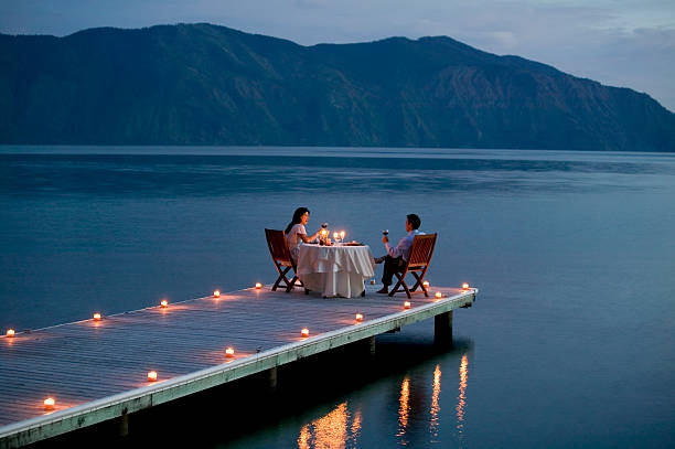 Couple Having Romantic Dinner Date on Pier - stock photo