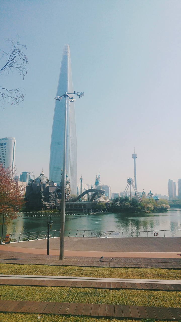 A park near a lake, amusement park and a Skyscraper.
