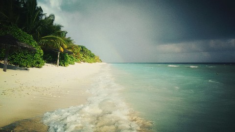 Beach in Maldives with rainbow