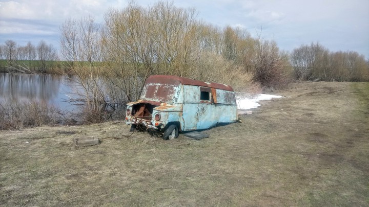 старый автомобиль на берегу пруда