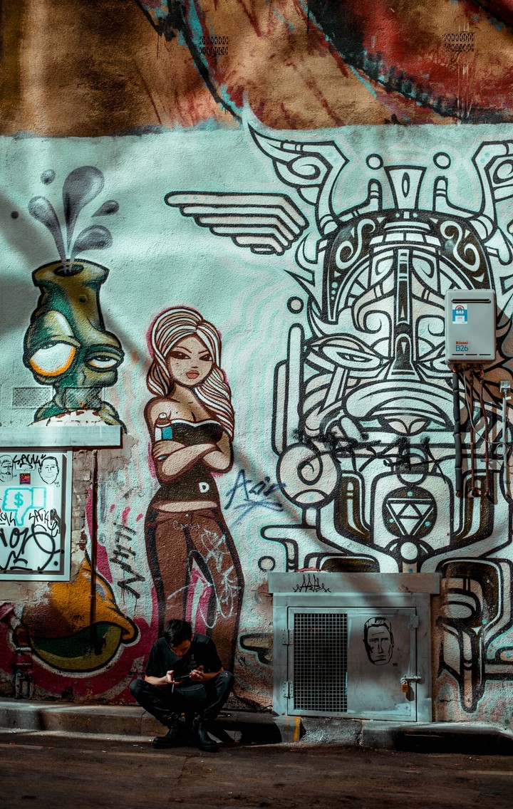 Man sitting in front of urban graffiti artwork in Melbourne