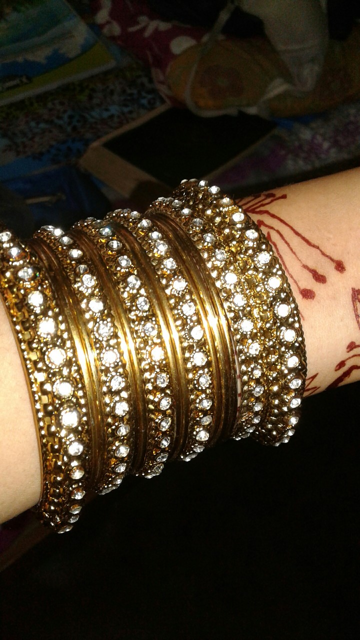golden bangles with white sparkle of stone .