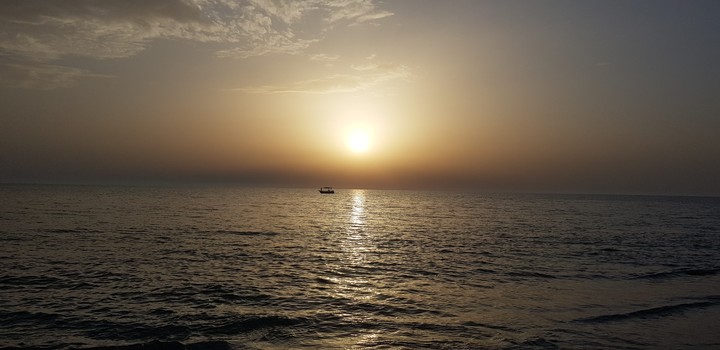 sea, sunset and a boat.