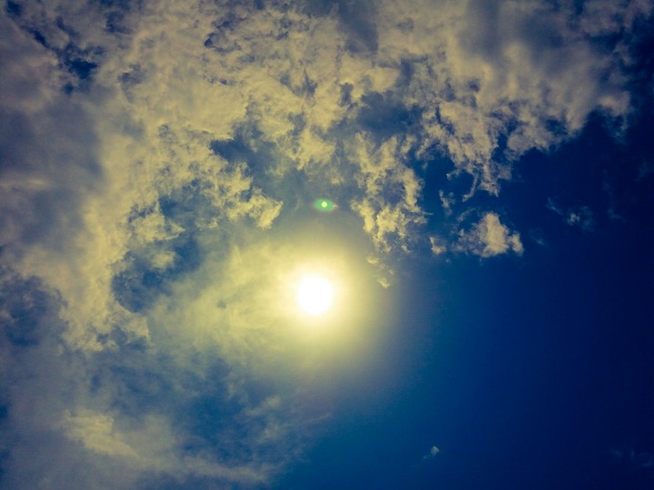 The sun is hiding behind the cloud.