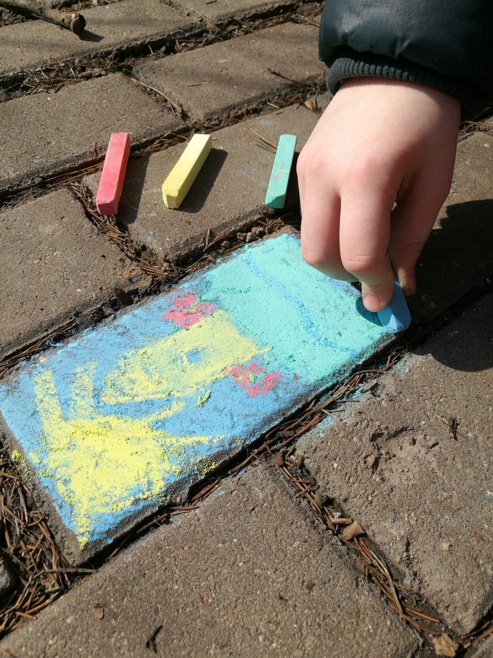 child drawing on the ground