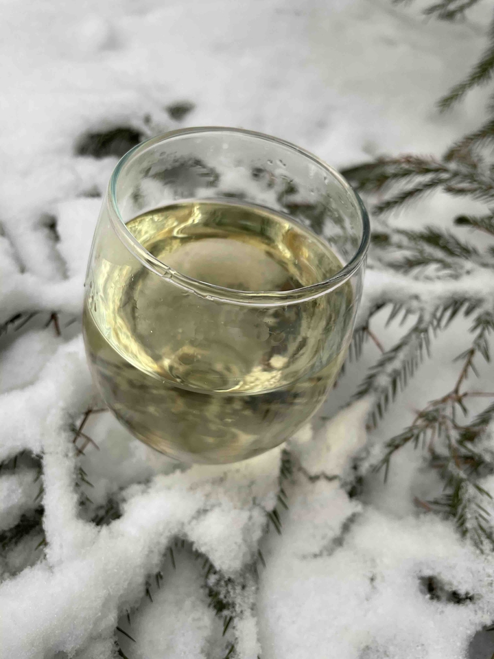 glass of white wine in snow