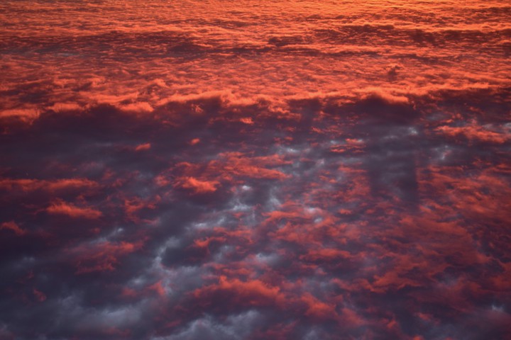 Flying over clouds at sunrise