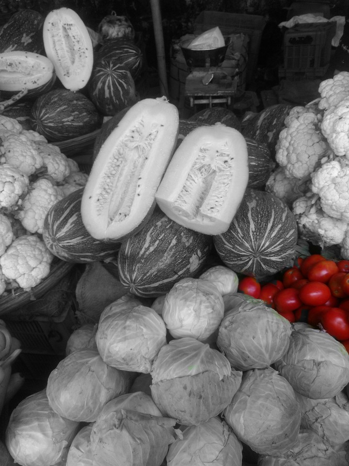 shiny tomatoes in middle green veggies