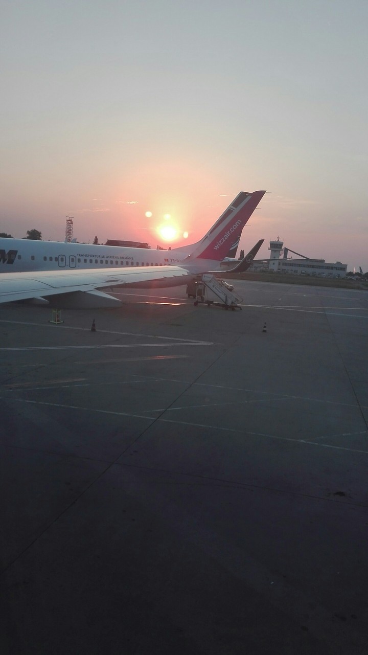 The sun rising at the airport .