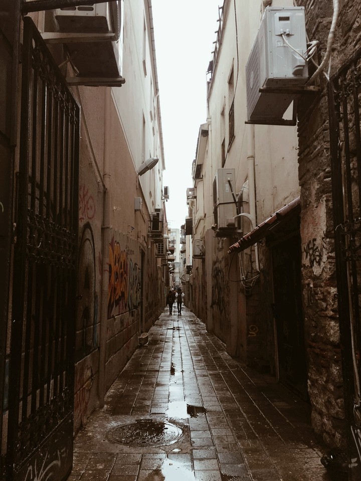 Yağmurlu cadde modern çizimlerin izleriyle.