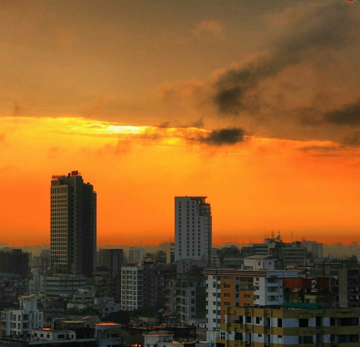 Sun Raising Behind Large Building