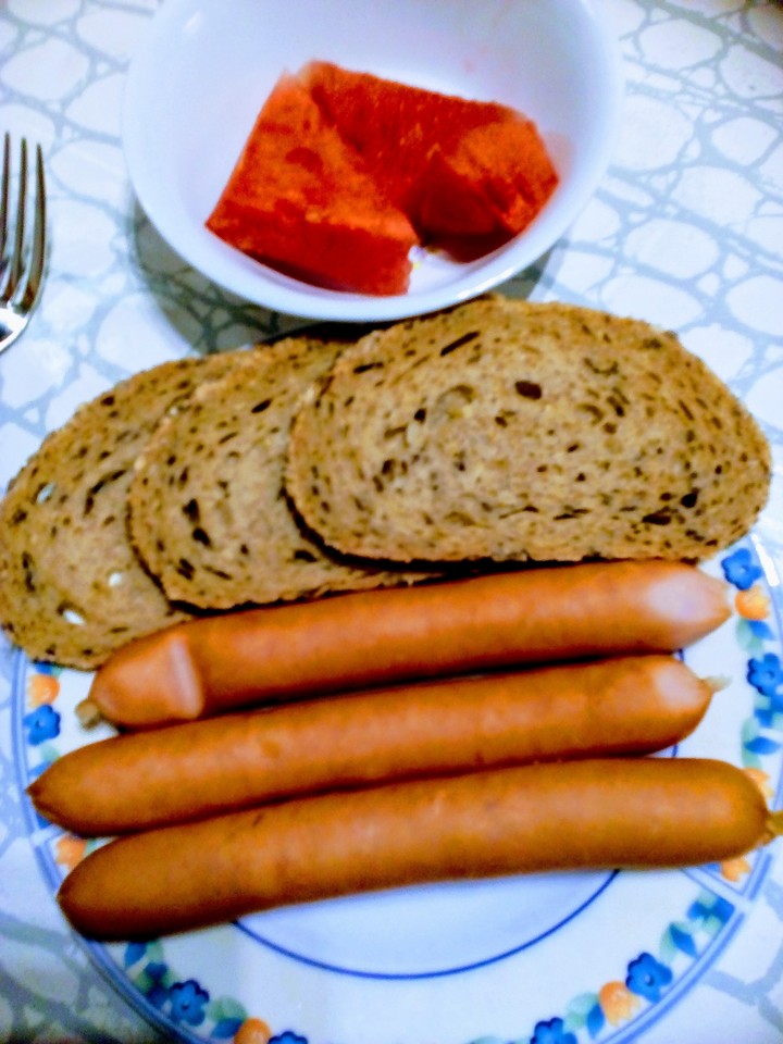 Käsewiener mit Graubrot und Melone.