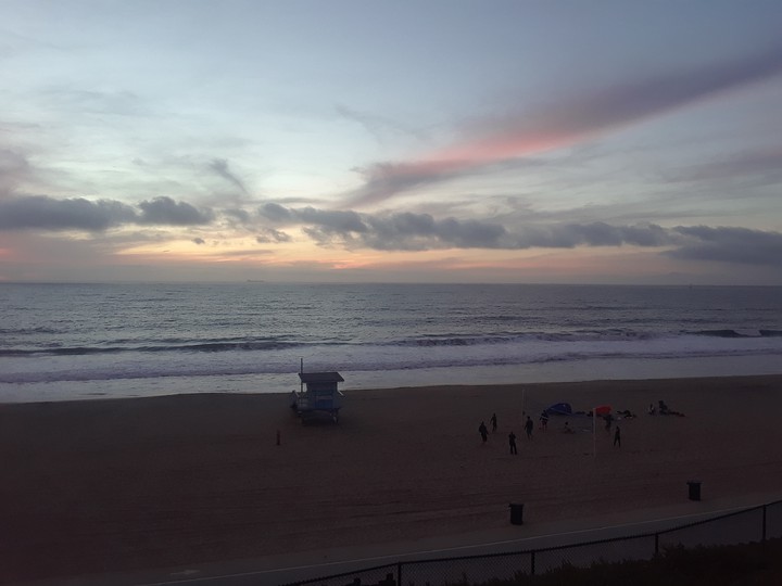 sunset at beach while people play volleyball