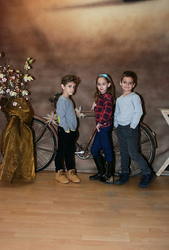 children posing by old bike