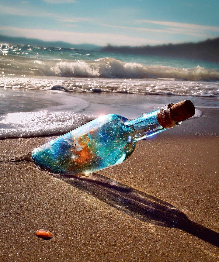 the universe in bottle on sand