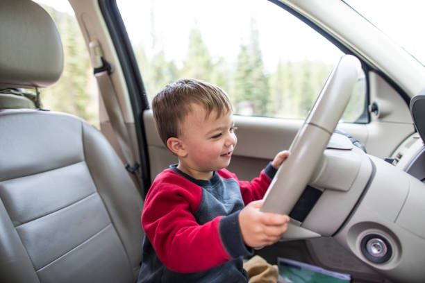 Little boy pretending to drive car - stock photo