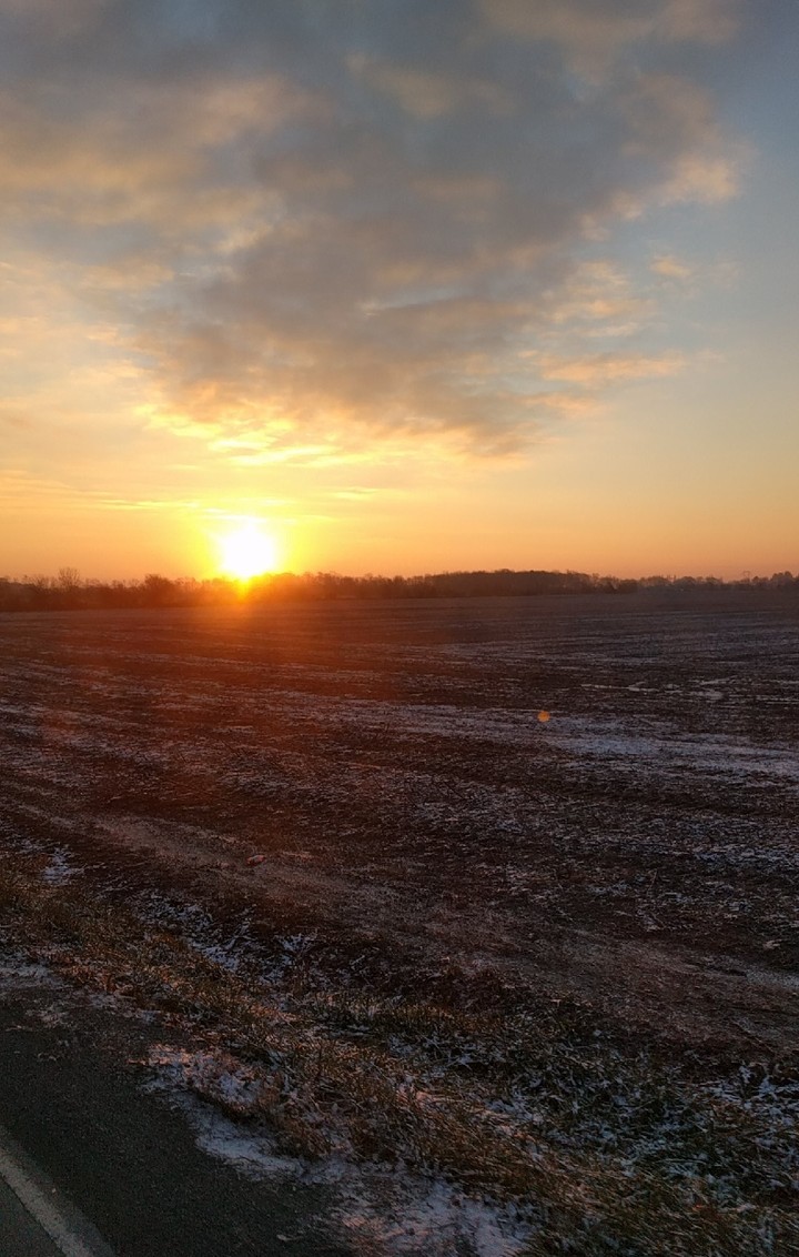Sun over snowy field