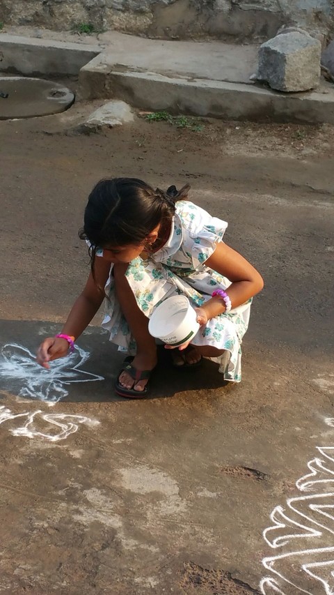 little one trying a monochromatic rangoli