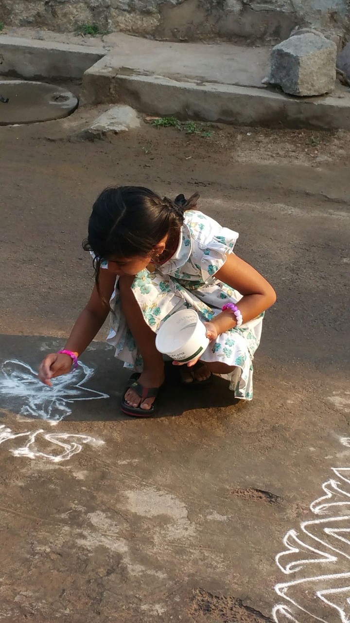 little one trying a monochromatic rangoli