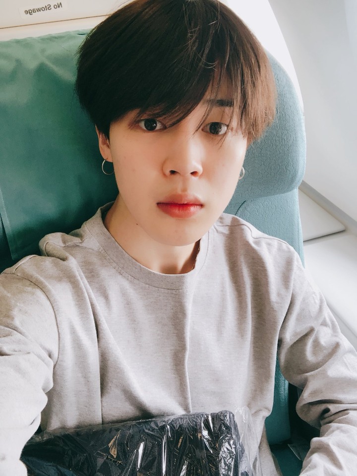 Jimin sitting in the plane to the USA