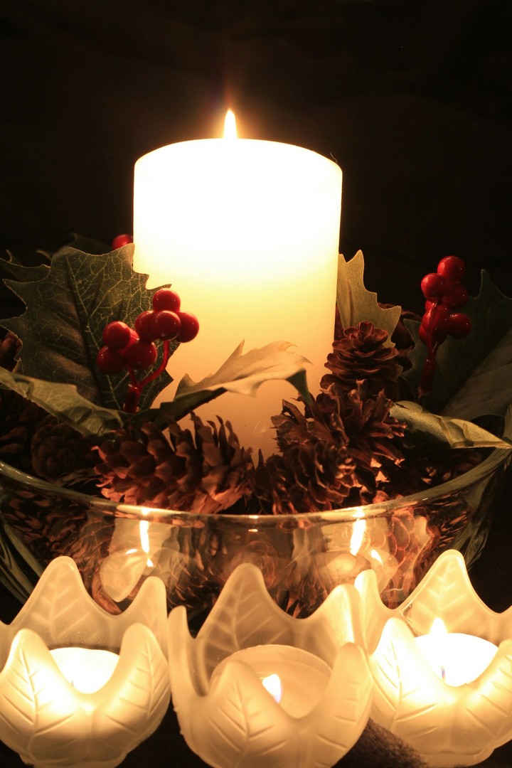 Christmas candles, holly, and pinecones
